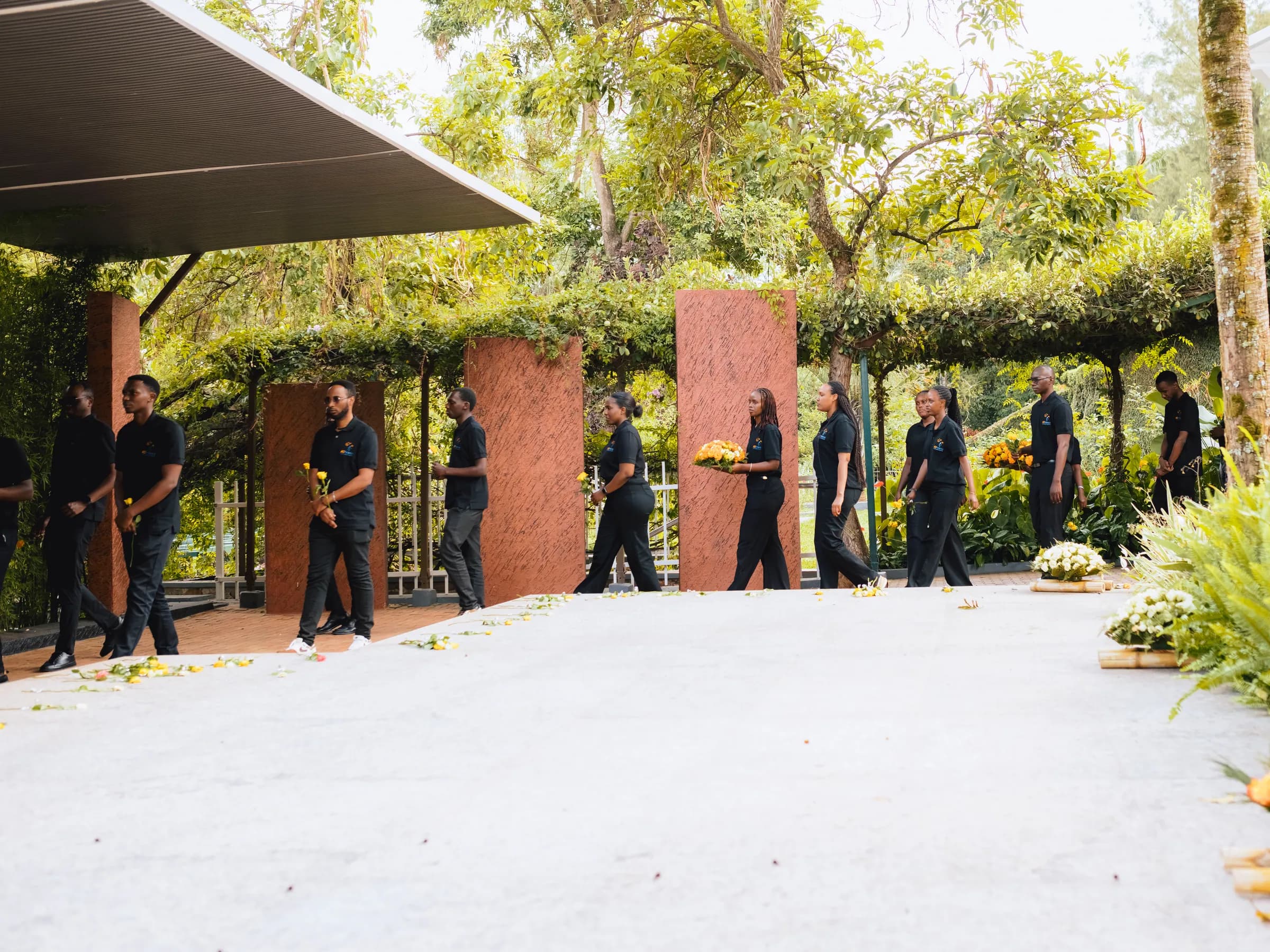 Team members carrying flowers towards the mass graves