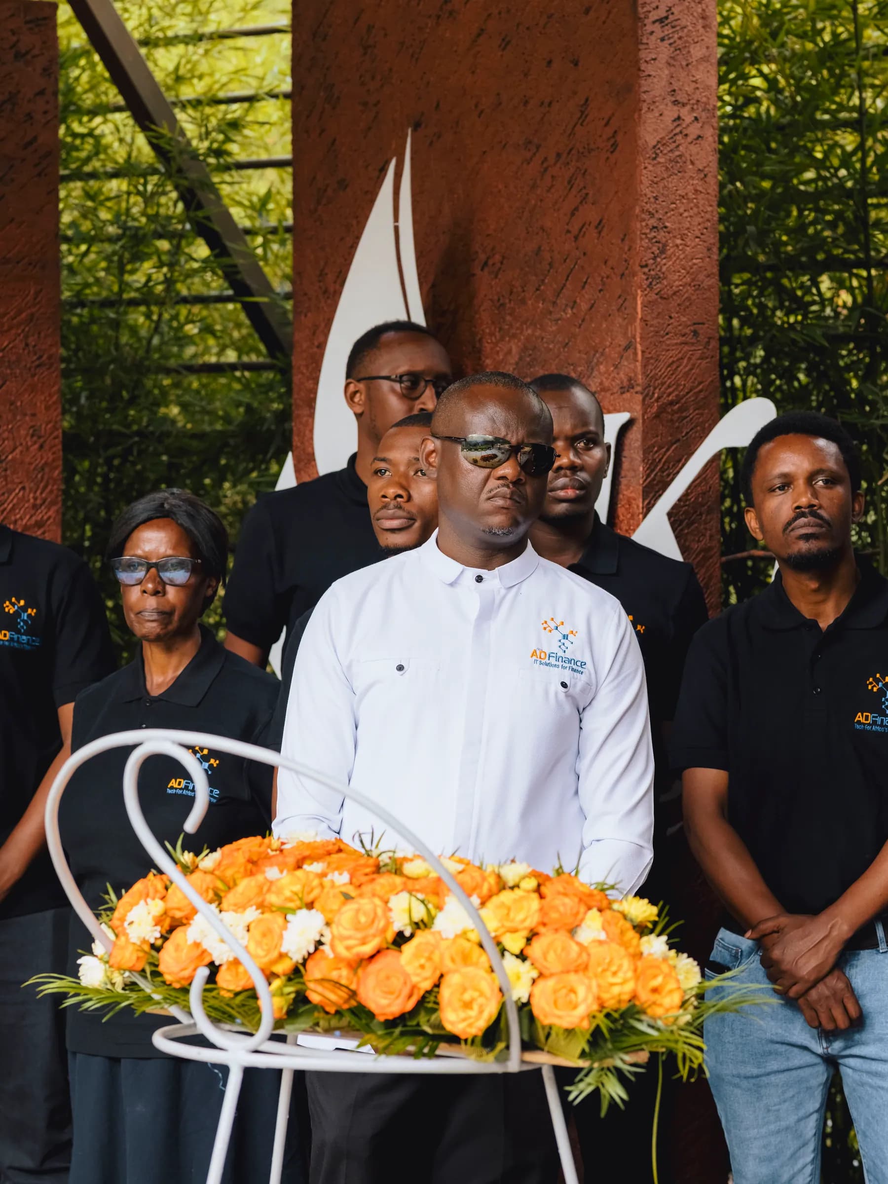 A member of the leadership team standing behind a wreath