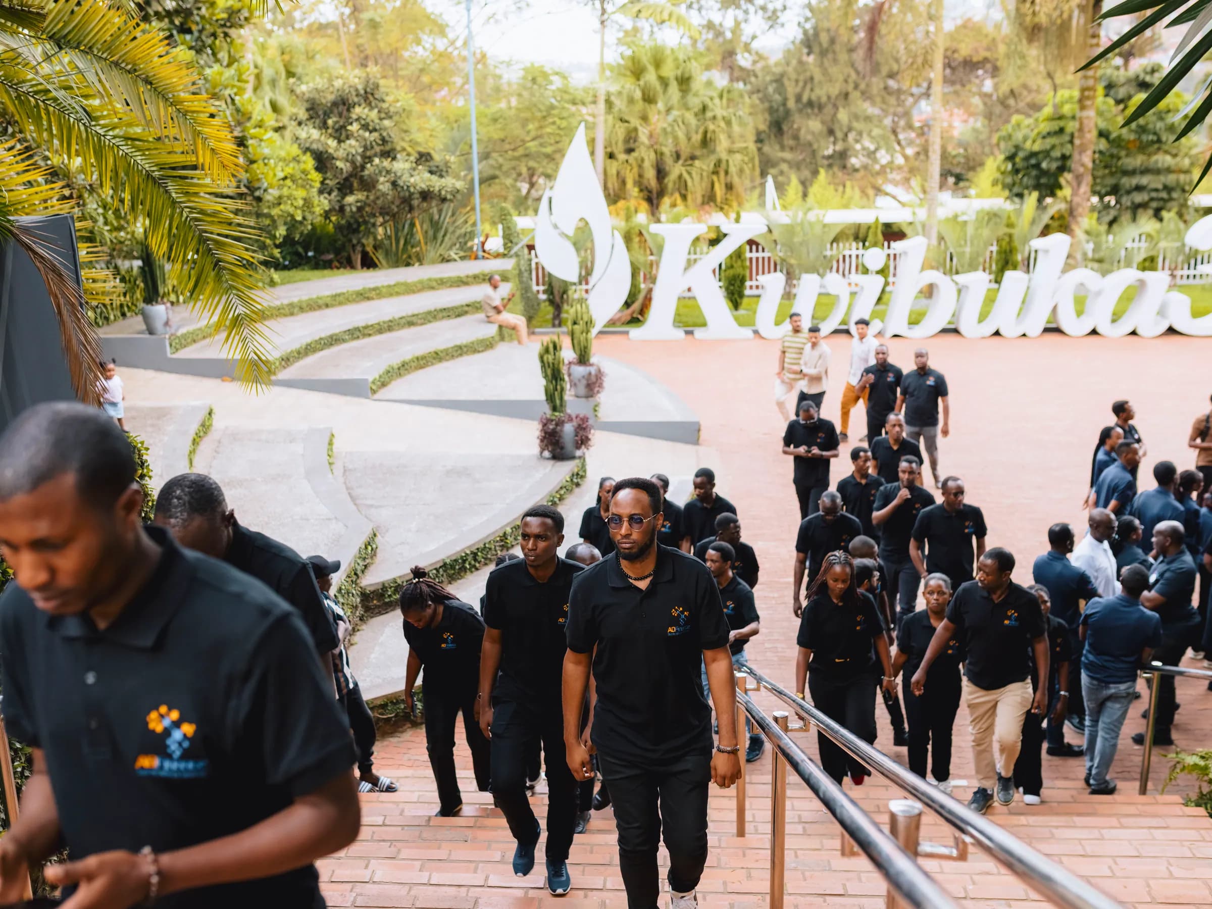 The team walking up the steps, with the Kwibuka 32 sign behind them